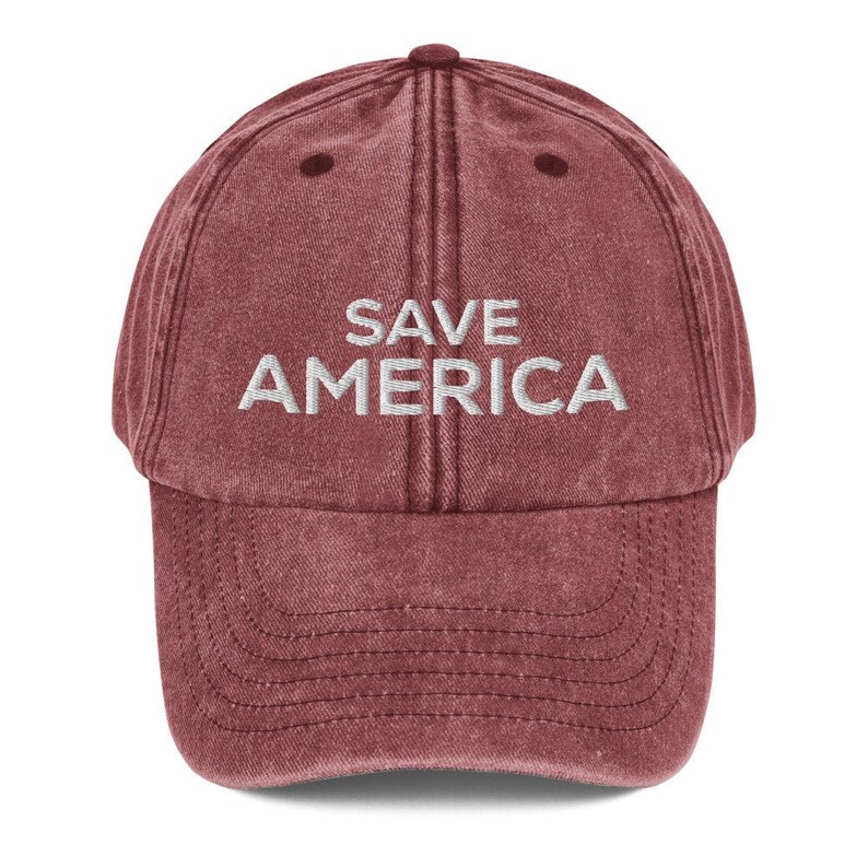 Puede incluir: Una gorra de b&eacute;isbol roja de estilo vintage con el texto "SAVE AMERICA" bordado en blanco en la parte delantera.