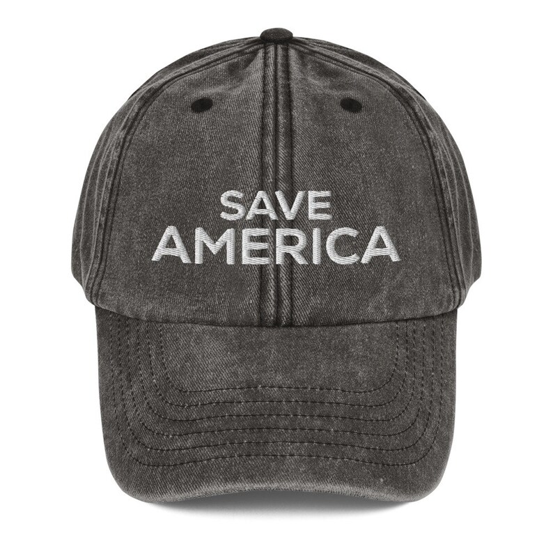 Puede incluir: Una gorra de b&eacute;isbol negra desgastada con texto blanco bordado que dice "SAVE AMERICA".