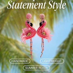 May include: A pair of pink flamingo earrings crafted with beads and sequins, featuring black and white accents, a central clear crystal, and long beaded legs. The text reads: Tropical Statement Style, HANDMADE, LIGHTWEIGHT, SUMMER READY, Marline H Boutique, @marlinehboutique.