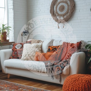 Könnte beinhalten: Ein weißes Sofa mit einer Vielzahl von bunten Kissen und Decken in einem Wohnzimmer. Das Sofa ist im Boho-Stil eingerichtet und verfügt über einen gewebten Wandbehang und Topfpflanzen.