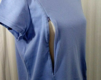 May include: A light blue, short-sleeved t-shirt with a zipper down the front. The zipper is open, revealing the inside of the shirt.