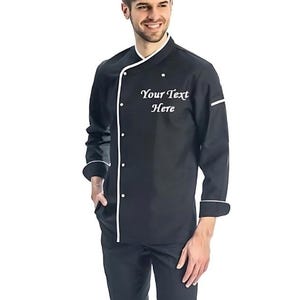 May include: Black chef jacket with white piping and a white embroidered design that says "Your Text Here".