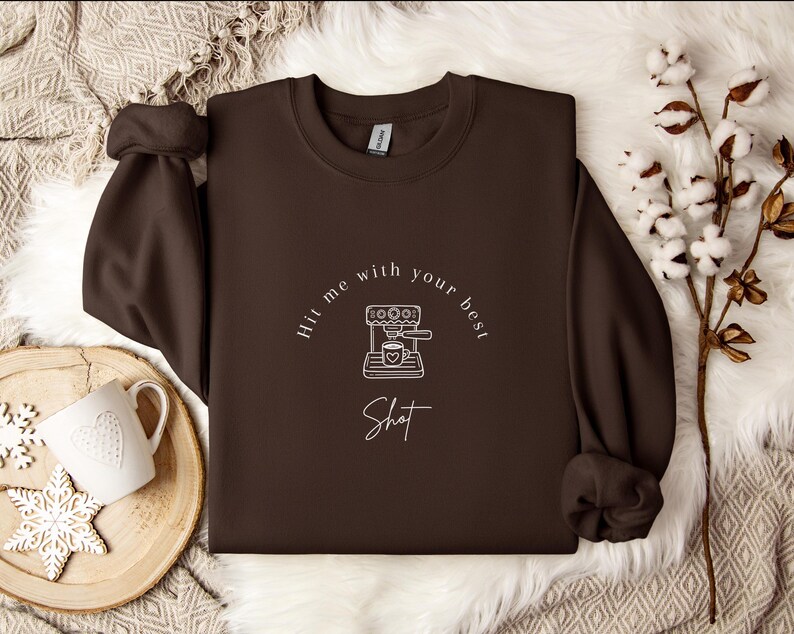May include: Brown sweatshirt with a white graphic of a coffee maker and the text "Hit me with your best shot".