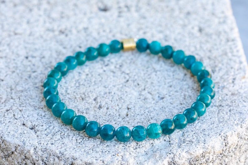 Pu&ograve; includere: Un braccialetto di pietre preziose blu turchese con una chiusura dorata.