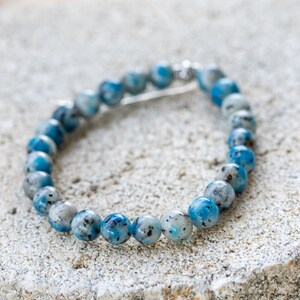 May include: A blue and white beaded bracelet with a silver clasp.