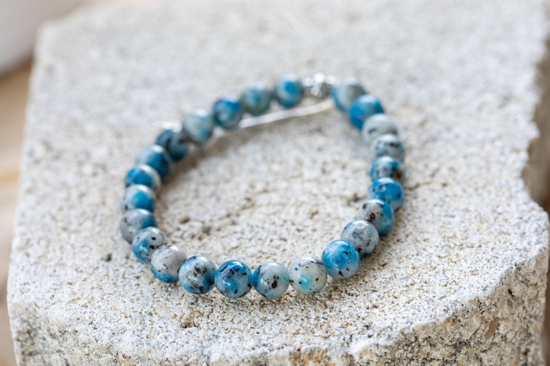 May include: A blue and white beaded bracelet with a silver clasp.