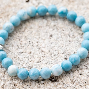 Peut inclure: Un bracelet en pierres pr&eacute;cieuses bleu clair avec un fermoir argent&eacute;. Le bracelet est compos&eacute; de perles rondes et est enfil&eacute; sur un cordon &eacute;lastique transparent.