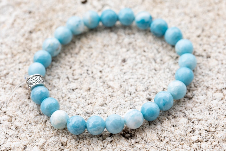 Peut inclure: Un bracelet en pierres pr&eacute;cieuses bleu clair avec un fermoir argent&eacute;. Le bracelet est compos&eacute; de perles rondes et est enfil&eacute; sur un cordon &eacute;lastique transparent.