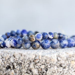 May include: A blue and white gemstone bracelet with round beads. The bracelet is made of natural stones and is a beautiful piece of jewelry.