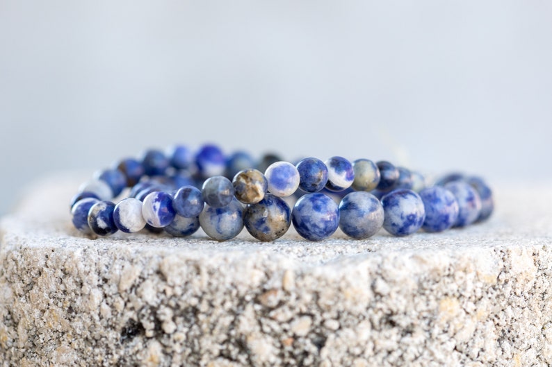 May include: A blue and white gemstone bracelet with round beads. The bracelet is made of natural stones and is a beautiful piece of jewelry.