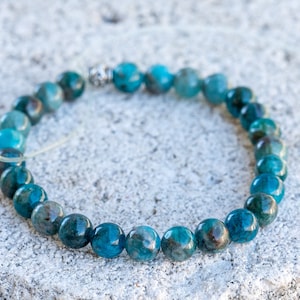 Pu&ograve; includere: Un braccialetto di pietre blu con accenti argentati. Il braccialetto &egrave; fatto di perline rotonde ed &egrave; infilato su un cordoncino elastico trasparente.