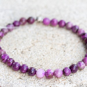 May include: A purple and white gemstone bracelet with a silver clasp.