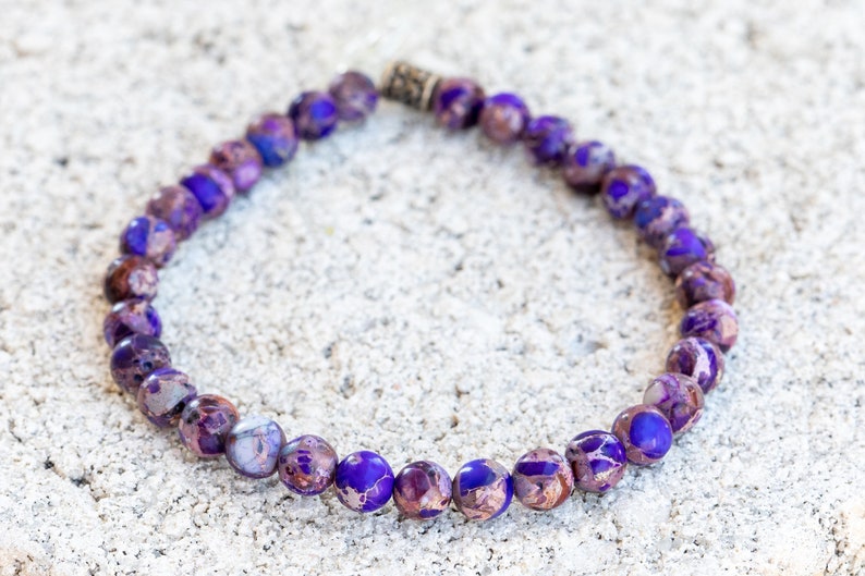 May include: A purple and brown beaded bracelet with a silver clasp.