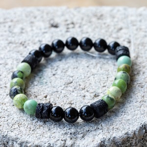 K&ouml;nnte beinhalten: Ein gr&uuml;nes und schwarzes Perlenarmband mit schwarzen Lavasteinen und gr&uuml;nen Serpentinperlen.