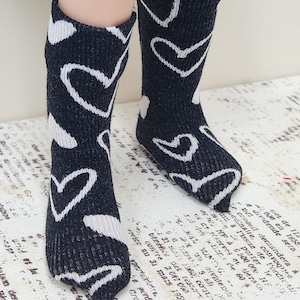May include: Black knee-high socks with a white heart pattern.