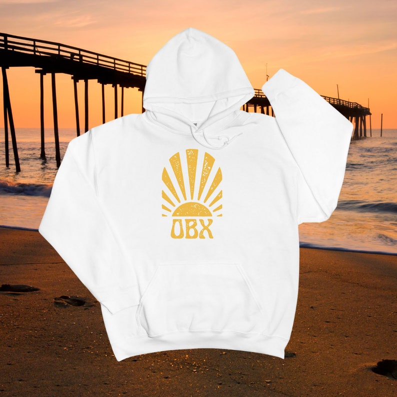 May include: White hooded sweatshirt with a yellow sun and the text "OBX" printed on the front.