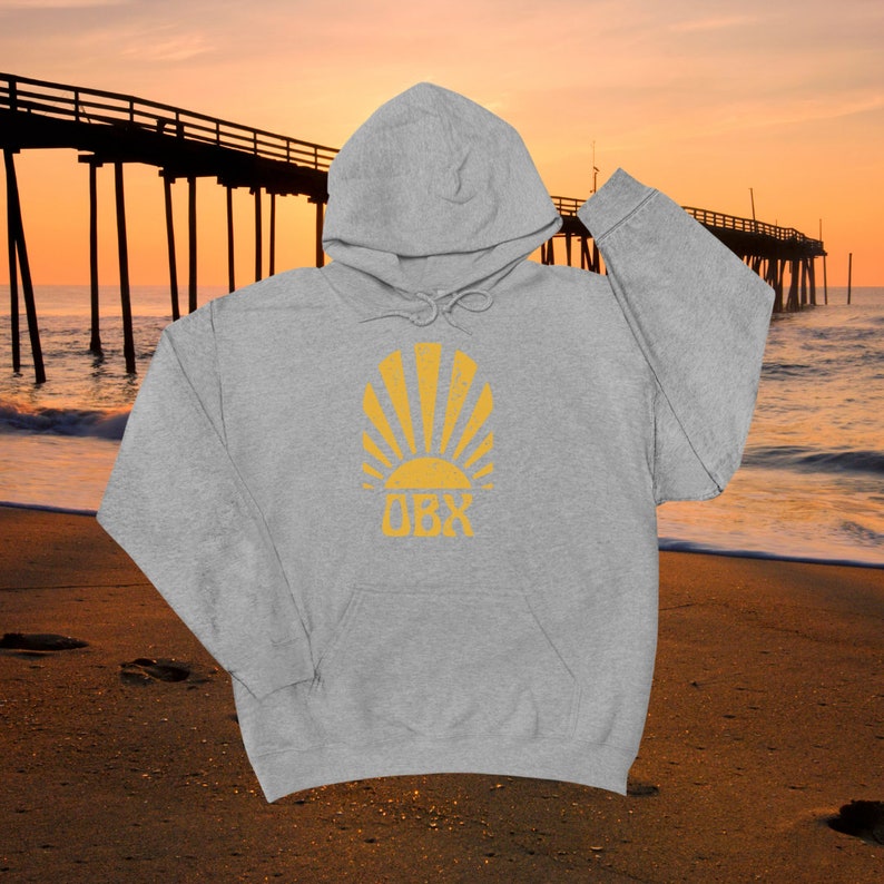 May include: A gray hooded sweatshirt with a yellow sun and the text "OBX" printed on the front.