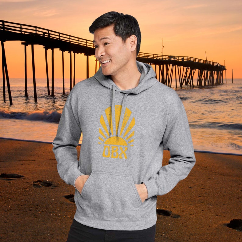 May include: A gray hooded sweatshirt with a yellow graphic of a sun rising over the text "OBX".