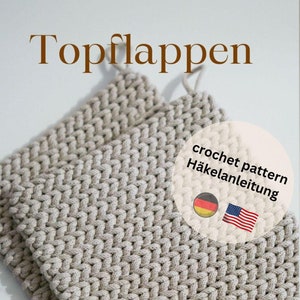 Puede incluir: Dos posavasos de ganchillo beige sobre un fondo blanco. La imagen incluye el texto "Topflappen" y "crochet pattern Häkelanleitung" en alemán. El texto "eine Anleitung von Wollmäuschen" también está incluido en alemán. La imagen incluye las banderas alemana y estadounidense.