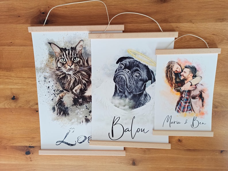 Puede incluir: Tres pinturas de acuarela enmarcadas sobre una superficie de madera. La primera pintura presenta un gato con el nombre "Lola" escrito debajo. La segunda pintura presenta un carlino con el nombre "Balou" escrito debajo. La tercera pintura presenta una pareja con los nombres "Maria & Ben" escritos debajo.