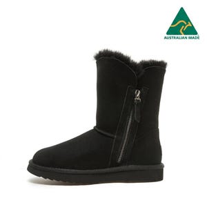 May include: A black suede mid-calf boot featuring a side zipper closure, a thick black rubber sole, and a plush black shearling lining visible at the top opening. The boot includes an Australian Made logo in the upper right corner.