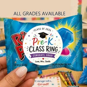 Puede incluir: Un paquete de caramelos azul con una pegatina Pre-K Class Ring. La pegatina tiene un gorro de graduación, un gráfico de diamante y el texto "Congrats, Grad!". El texto "All Grades Available" está en la parte superior.