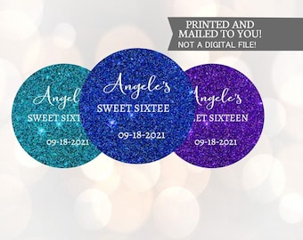 Könnte beinhalten: Drei runde, glitzernde Aufkleber mit dem Text "Angel's Sweet Sixteen" und dem Datum "09-18-2021". Die Aufkleber sind in den Farben Türkis, Blau und Lila.