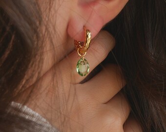 Boucles d'oreilles créoles or épaisses acier inoxydable martelé avec pendentif ovale facetté en cristal vert péridot pastel, modèle Illusion