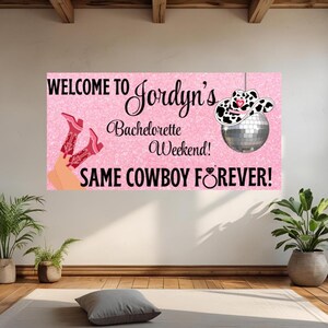Può includere: Un banner rosa con la scritta "WELCOME TO Jordyn's Bachelorette Weekend! SAME COWBOY FOREVER!" presenta una palla da discoteca con un cappello da cowboy e stivali da cowboy rosa. Il banner è appeso a un muro.