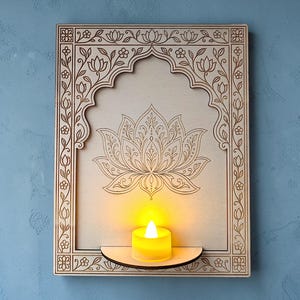 May include: A rectangular light-coloured wooden wall plaque featuring an arched frame with intricate floral engravings and a central lotus flower design. A small semi-circular shelf extends from the bottom, holding a glowing yellow LED tea light.
