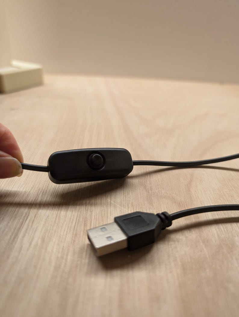 May include: A black USB cable with an inline on/off switch. The cable is connected to a USB plug.