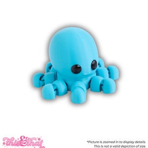 May include: A light blue 3D-printed octopus figurine with large black eyes. The octopus has eight curved tentacles and a rounded head. The image includes the text "This & That Company" and a disclaimer about the image's zoom and color variations.
