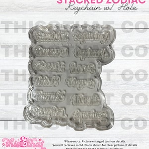 May include: A clear plastic mold for making zodiac keychain charms. The mold features all 12 zodiac signs in a stacked design. The mold is designed to be used with resin or other casting materials.