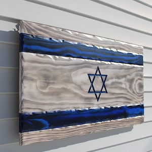 May include: A wooden sign with the Israeli flag painted on it. The flag is blue and white with a six-pointed star in the centre.