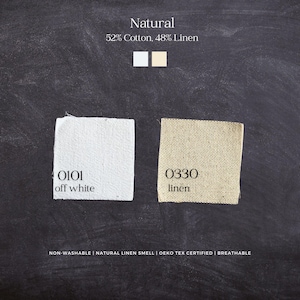 Op de afbeelding: Twee stofstalen met het label Natural, 52% Cotton, 48% Linen. E&eacute;n staal is gelabeld 0101 off white, de andere 0330 linen. Tekst bevat Non-washable, Natural linen smell, Oeko Tex certified, Breathable. De achtergrond heeft een donkere schoolbordtextuur.
