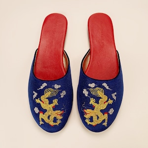 May include: A pair of blue satin slippers with gold embroidered dragons and red accents.