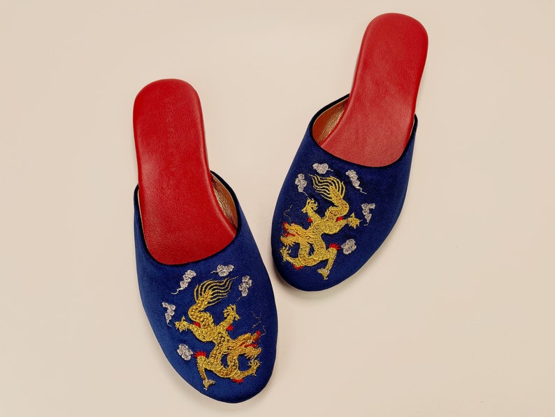 May include: A pair of blue velvet slippers with red lining and gold embroidered dragons.