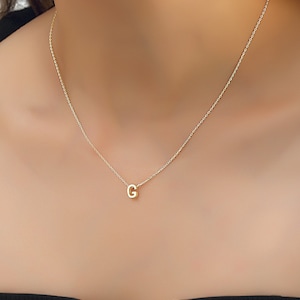 May include: A gold chain necklace with a small gold letter G pendant.