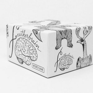 May include: A white box with black and white illustrations of a brain, a bear, and a bird. The box says "featherbrain" and "word game".