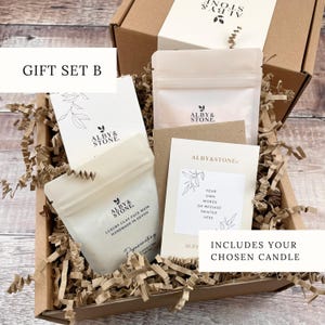A gift set containing a luxury face mask, a chosen candle, and a card, all wrapped in a brown cardboard box with shredded paper.
