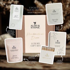 The image is a promotional material for a luxury gift set from Alby & Stone, featuring various items such as a chocolate bar, a face mask, a clay mask, a matchbox, and a candle.