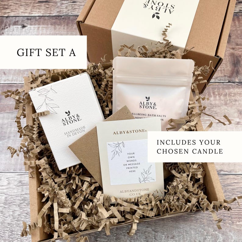 A gift set containing a box, a card, and a bag, all wrapped in brown paper and placed in a cardboard box with shredded paper.