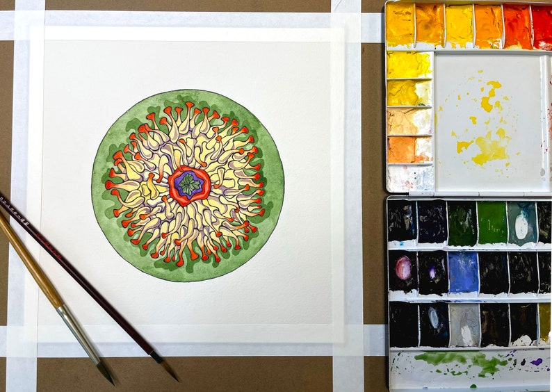 May include: A watercolor painting of a circular mandala with a green, orange, yellow, and purple color scheme. The mandala is surrounded by a white border.