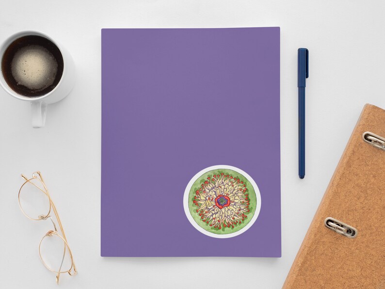 May include: A colorful sticker with a circular design featuring a flower with red, yellow, and green petals. The flower is surrounded by a green circle with a white border.