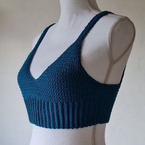 May include: Teal blue crocheted crop top with a V-neck and thin straps.