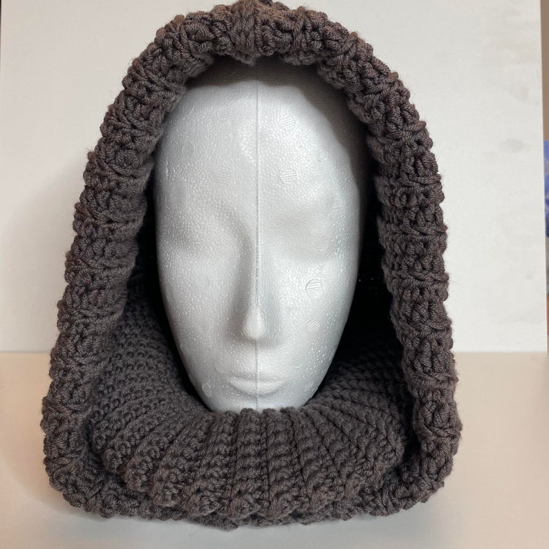 Turtleneck Hoodie Crocheted in brown Wool yarn on a styrofoam head.