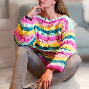 May include: A colorful striped crochet sweater in pink, yellow, green, and blue.