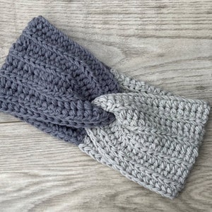 May include: A gray and dark gray crocheted headband with a twisted knot design.
