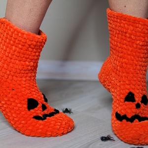 May include: A pair of orange fuzzy socks with a black jack-o'-lantern face on the toe. The socks are made of a soft, plush material and are perfect for keeping your feet warm during the fall and winter months.