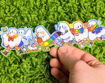 May include: A sticker featuring a line of seven cartoon ghosts wearing rainbow-colored clothing and accessories. The ghosts are holding hands and walking together. The sticker is on a green background.